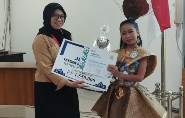 Nafisa Qirla Rindani saat menerima hadiah sebagai Juara I dalam Featival Lomba Busana Daur Ulang Universitas Darwan Ali Sampit