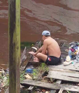 Aktivitas warga mandi dan mencuci pakaian di Sungai Mentaya sekitar lokasi pencemaran limbah minyak yang diduga dibuang secara sengaja oleh anak buah kapal yang tambat di sekitar lokasi tersebut.