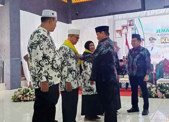 Bupati Kotim Halikinnor menyematkan atribut kepada calon jemaah haji simbol pelepasan pemberangkatan haji tahun 2025, di aula Islamic Center, Selasa, 13 Mei 2025.