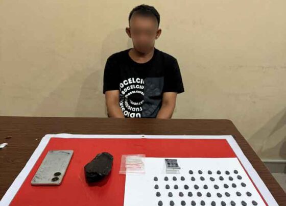Pelaku beserta barang bukti puluhan butir pil ekstasi saat diamankan di Polresta Palangka Raya.